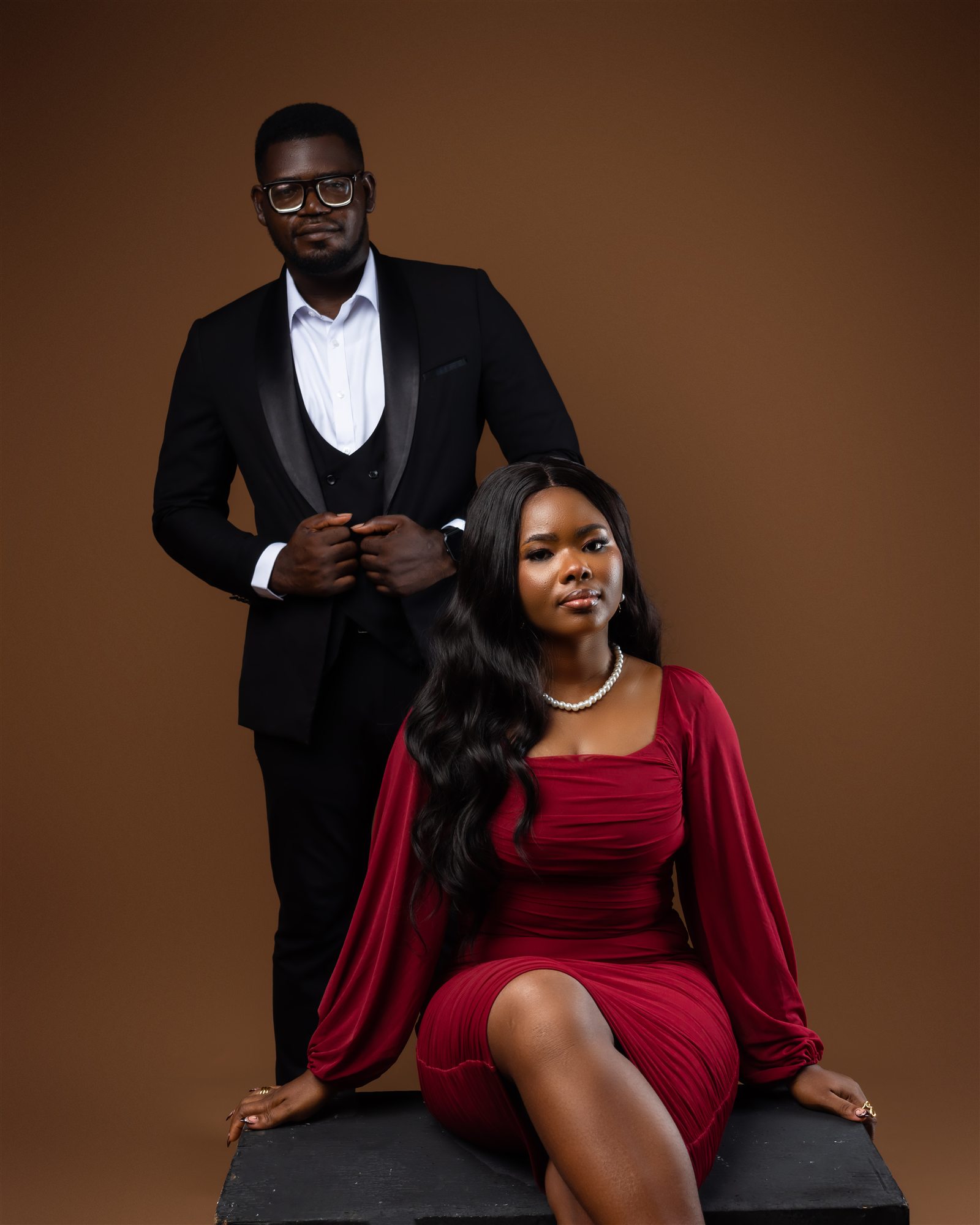 An elegantly dressed engaged couple in a formal portrait.